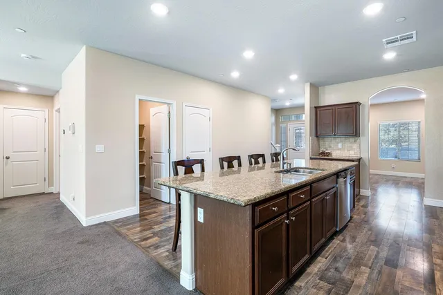a kitchen with stainless steel appliances granite countertop a sink stove and cabinets