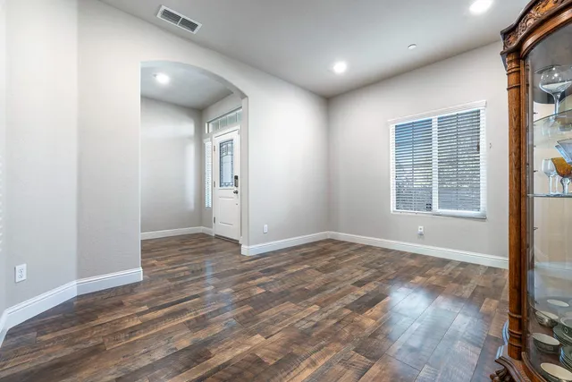 a kitchen with stainless steel appliances kitchen island granite countertop a table chairs and a refrigerator
