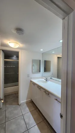 a spacious bathroom with a granite countertop sink a mirror and a vanity