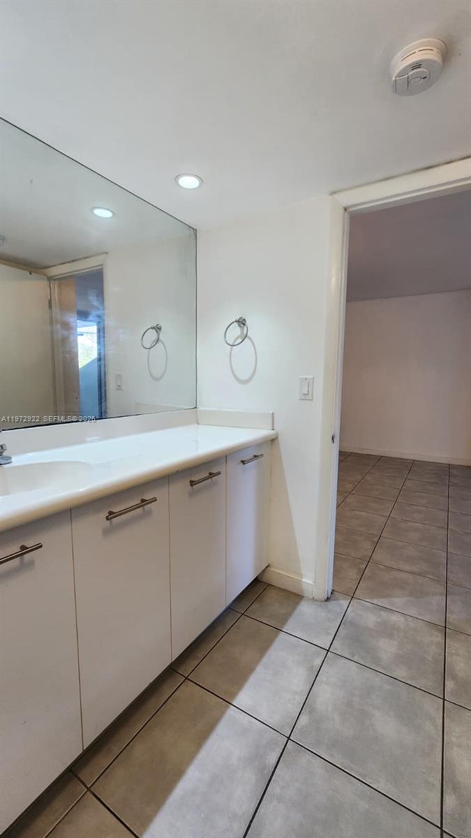680 Northeast 64th Street, Unit A215 Miami, FL 33138 - Photo 19 of 24 a spacious bathroom with a granite countertop sink a mirror and a vanity