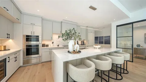 a kitchen with granite countertop white cabinets and stainless steel appliances