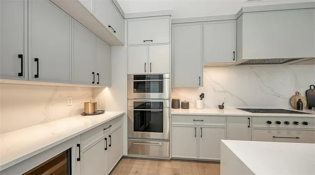 a kitchen with stainless steel appliances a sink stove and white cabinets