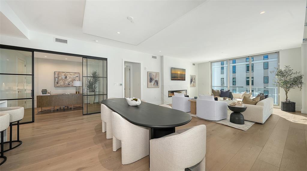 253 Golden Gate Point, Unit 703 Sarasota, FL 34236 - Photo 18 of 51 a living room with couches a coffee table and chairs with wooden floor