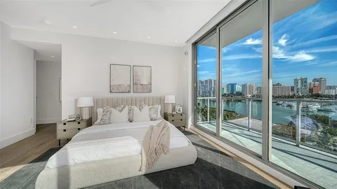 a bedroom with a large window and a balcony