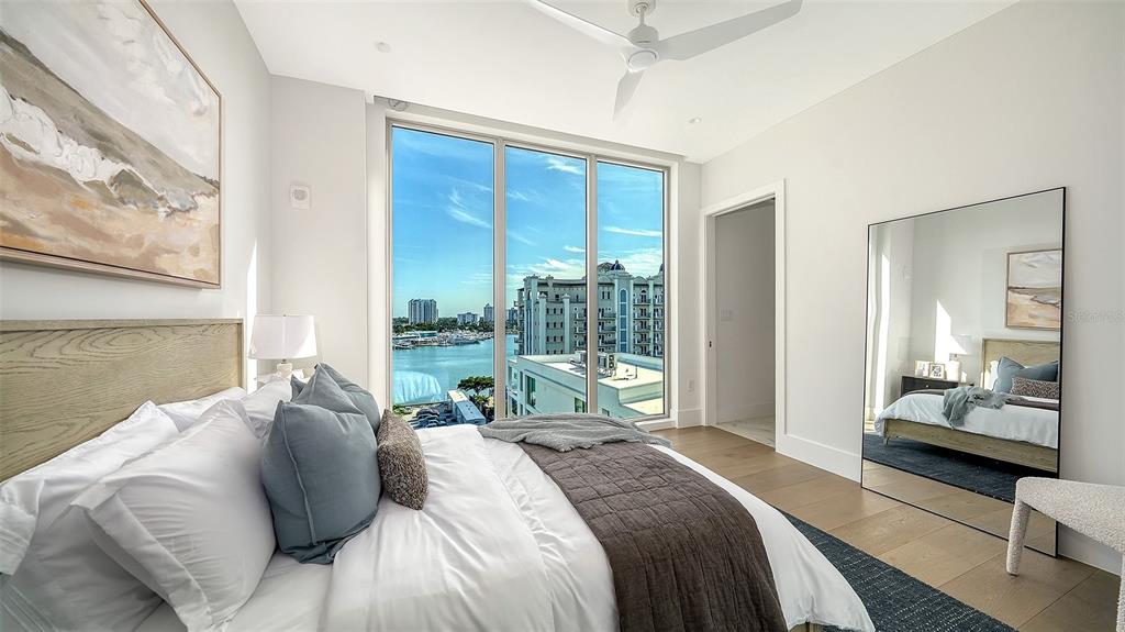 253 Golden Gate Point, Unit 703 Sarasota, FL 34236 - Photo 28 of 51 a bedroom with a bed and large windows