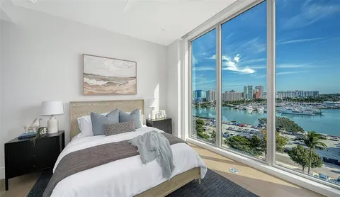 a bedroom with a bed and large window