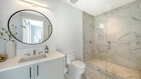 a bathroom with a sink a toilet and a mirror