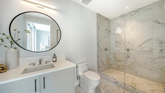 a bathroom with a sink a toilet and a mirror