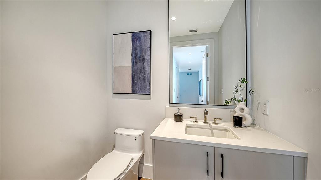 253 Golden Gate Point, Unit 703 Sarasota, FL 34236 - Photo 34 of 51 a bathroom with a toilet sink and mirror