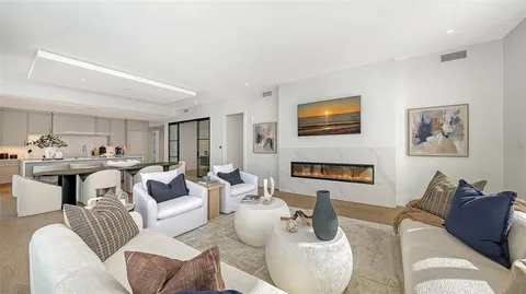 a living room with furniture kitchen view and a fireplace
