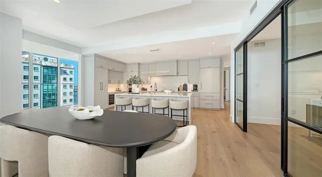 a kitchen with a dining table chairs and refrigerator
