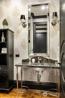 a bathroom with a granite countertop sink and washing machine