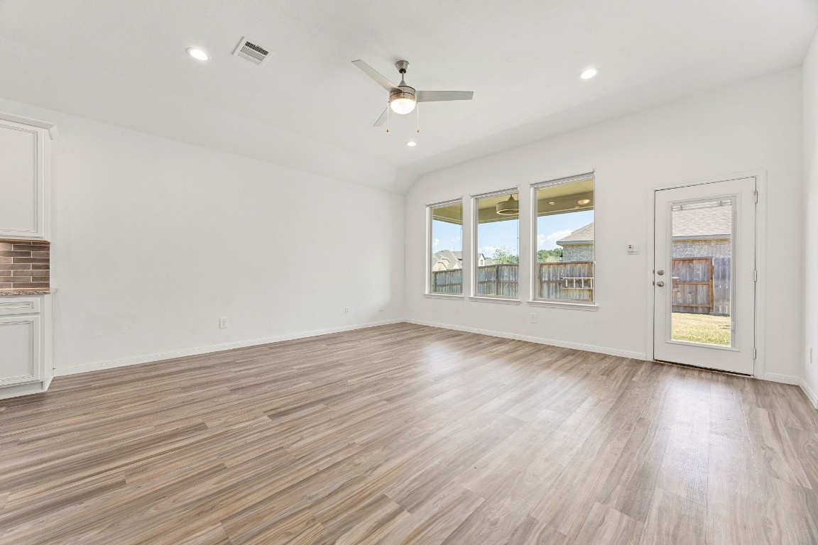 907 Youth Water Road Montgomery, TX 77316 - Photo 2 of 31 an empty room with wooden floor and windows