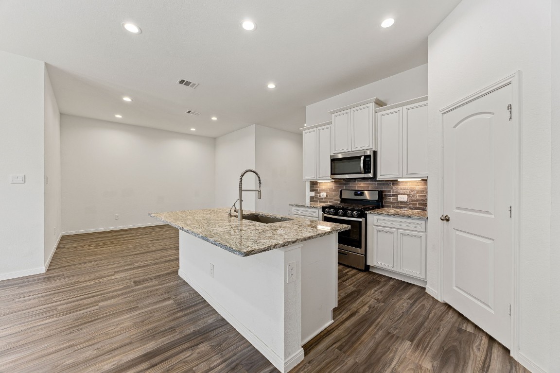 907 Youth Water Road Montgomery, TX 77316 - Photo 4 of 31 a kitchen with stainless steel appliances granite countertop a stove a sink and a refrigerator