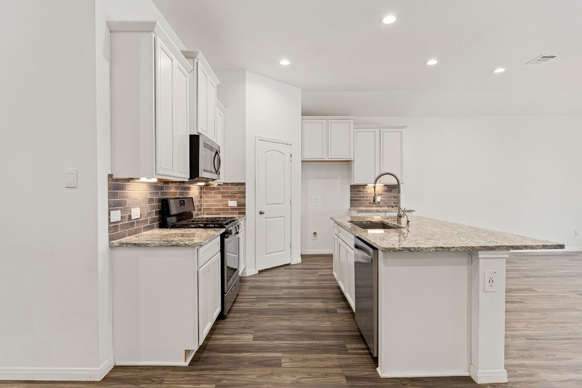 907 Youth Water Road Montgomery, TX 77316 - Photo 6 of 31 a kitchen with stainless steel appliances granite countertop a stove top oven a sink and dishwasher