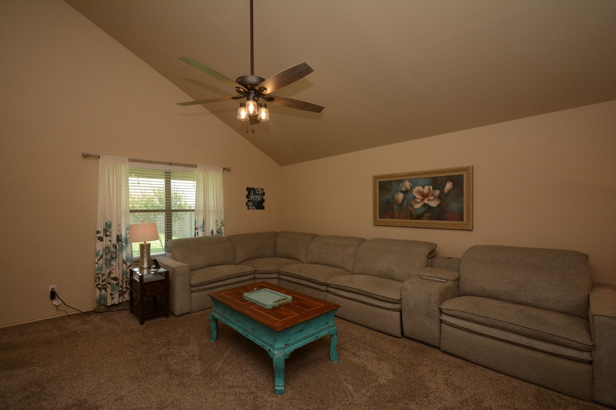 23318 Dukes Run Drive Spring, TX 77373 - Photo 16 of 41 This cozy living room features a vaulted ceiling, large sectional sofa, ceiling fan, and natural light from a window, overlooking the lush backyard.
