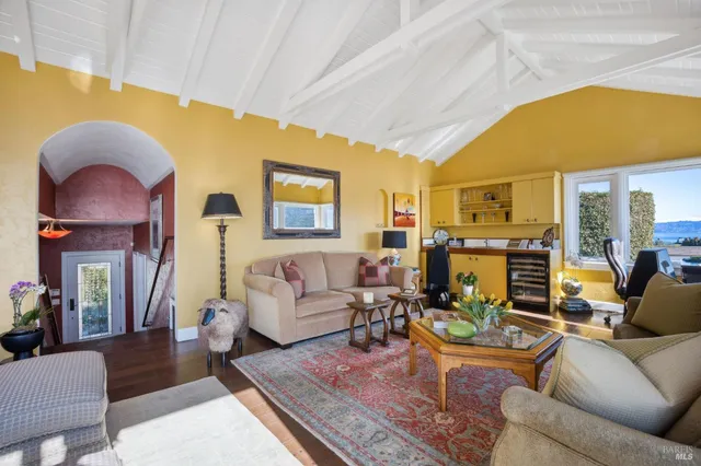 a living room with fireplace furniture and a large window