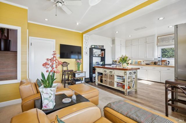 a living room with furniture kitchen view and a large window