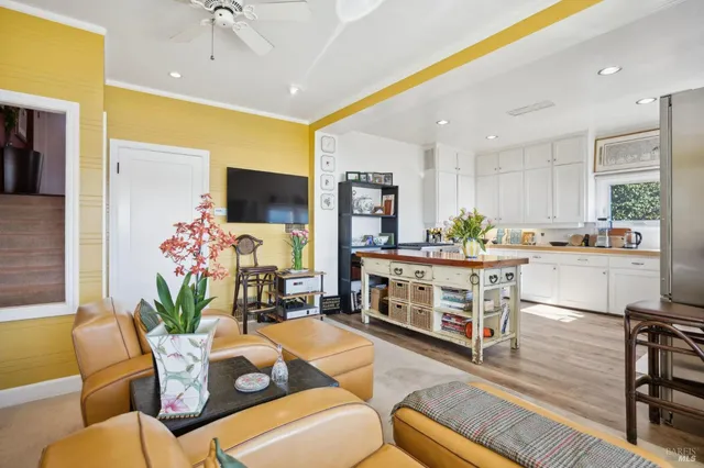 a living room with furniture kitchen view and a large window