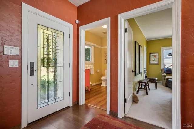 a view of a hallway with wooden floor and furniture