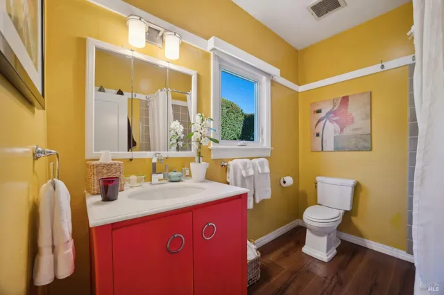 a bathroom with a granite countertop toilet sink and mirror