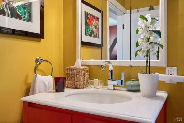 a bathroom with a granite countertop sink and a mirror
