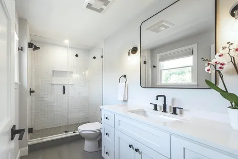 a bathroom with a sink a toilet and shower