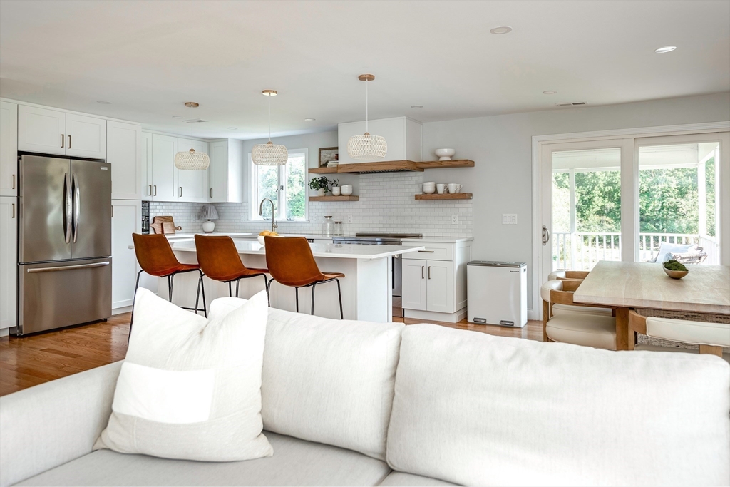 22 Sagamore Road Ipswich, MA 01938 - Photo 8 of 39 a living room with stainless steel appliances kitchen island granite countertop a table chairs and a refrigerator