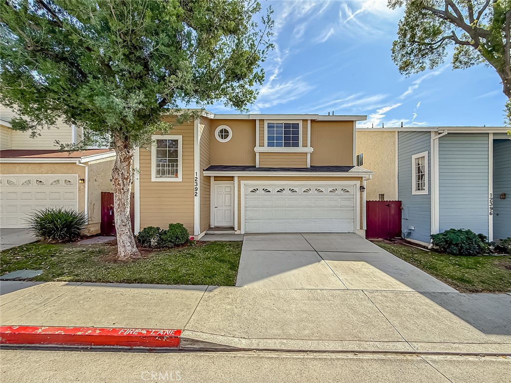 12392 Carl Street Pacoima, CA 91331 - Photo 1 of 55 a front view of a house with a yard and garage