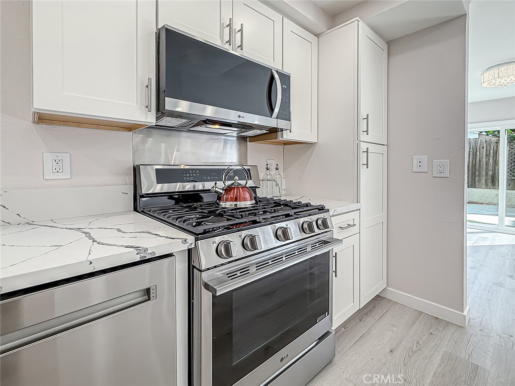 12392 Carl Street Pacoima, CA 91331 - Photo 21 of 55 a kitchen with stainless steel appliances granite countertop a stove microwave and sink