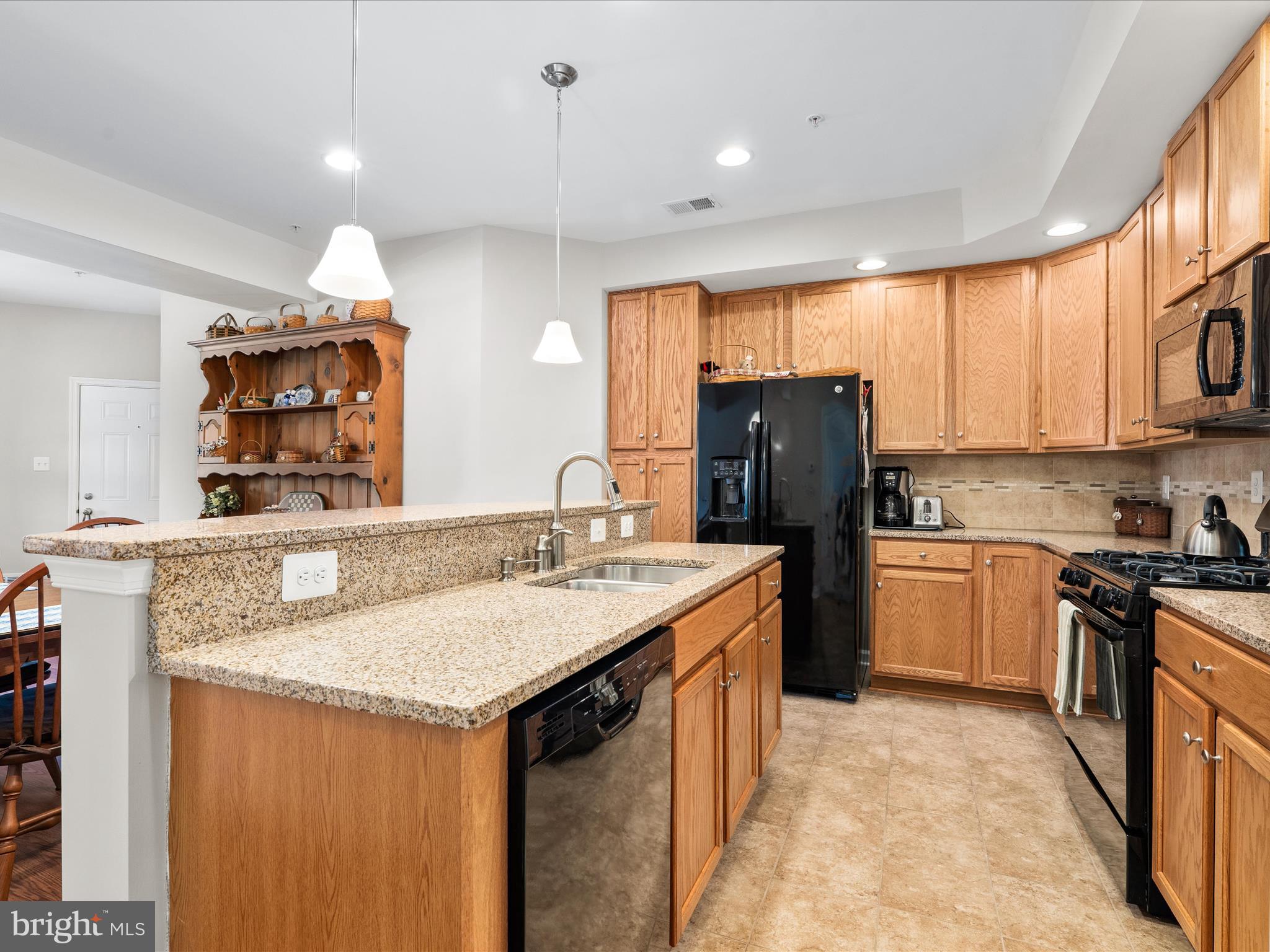 5039 Small Gains Way Frederick, MD 21703 - Photo 4 of 34 a kitchen with stainless steel appliances granite countertop a sink stove and refrigerator