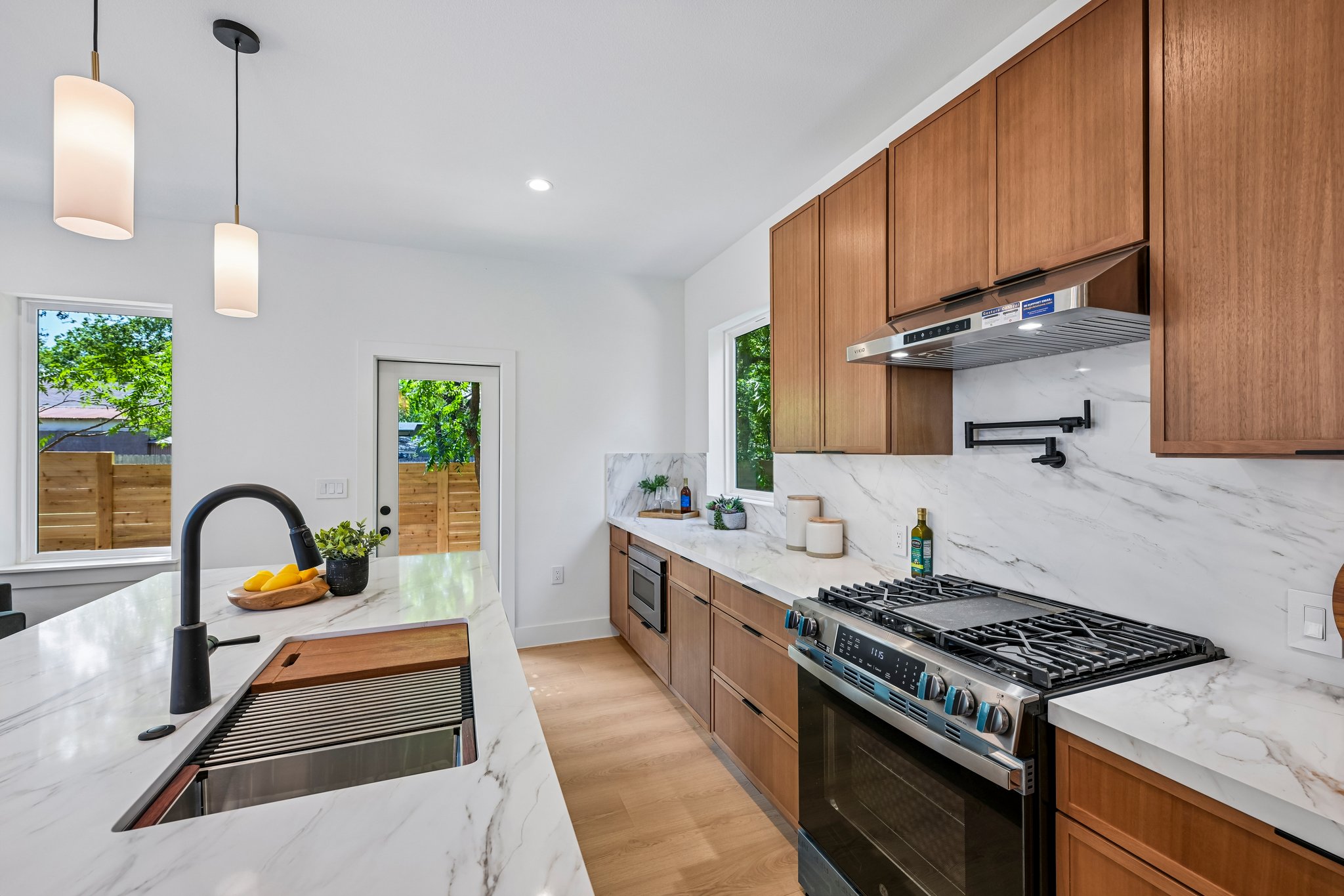 513 West Odell Street, Unit B Austin, TX 78752 - Photo 13 of 38 Culinary adventures await in this naturally illuminated kitchen, with sleek quartz countertops and a convenient pot filler.