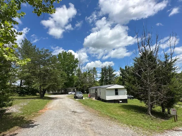 a front view of a house with a garden and trees