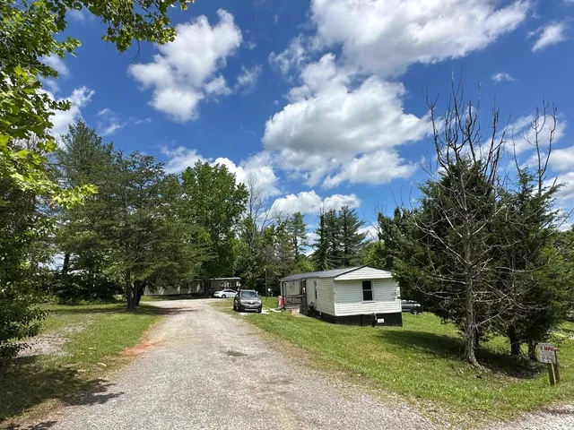 a front view of a house with a garden and trees