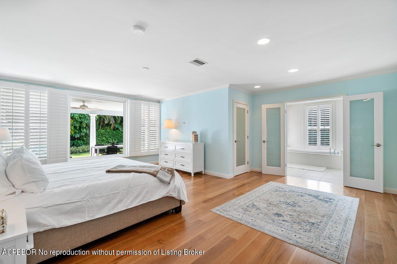 256 Mockingbird Trail Palm Beach, FL 33480 - Photo 13 of 25 a spacious bedroom with a large bed and a wooden floor
