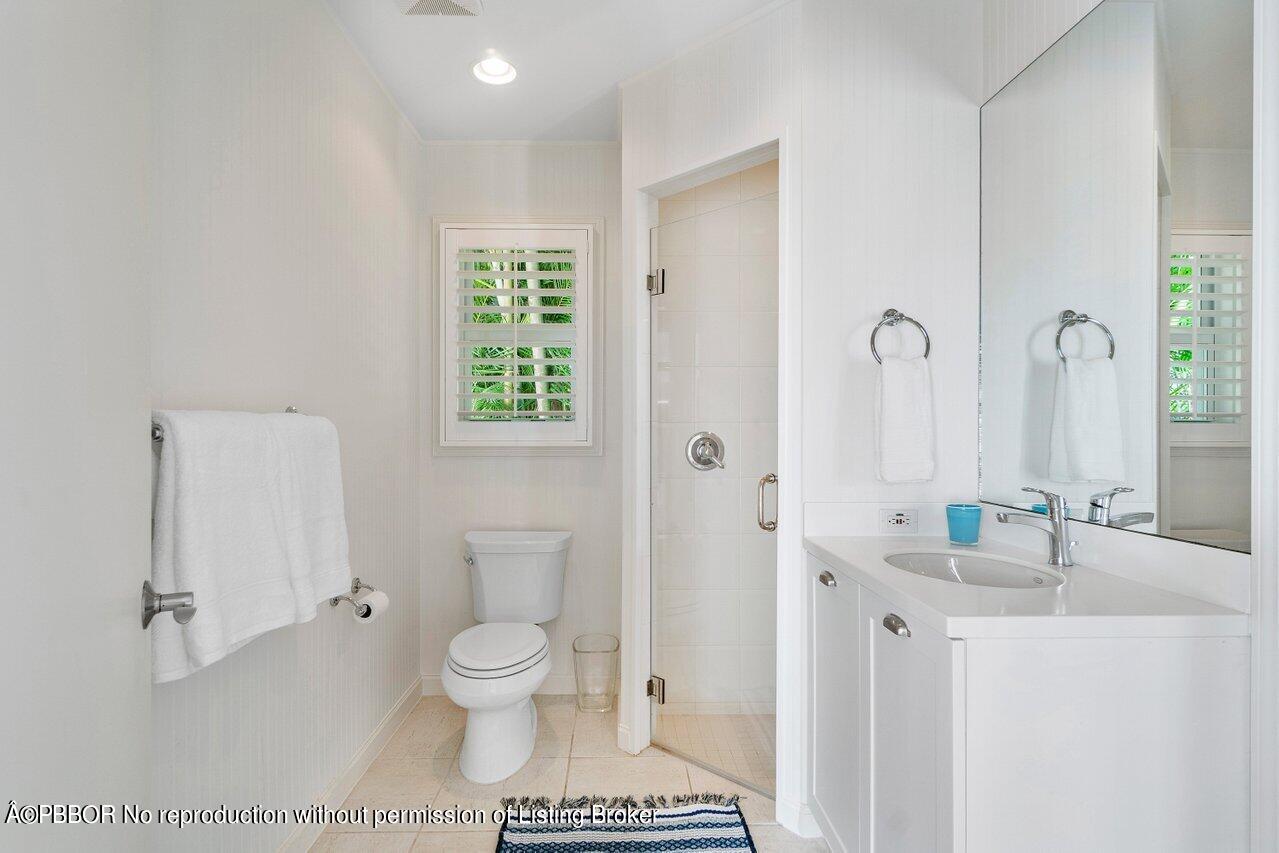 256 Mockingbird Trail Palm Beach, FL 33480 - Photo 20 of 25 a bathroom with a granite countertop toilet a sink and a mirror