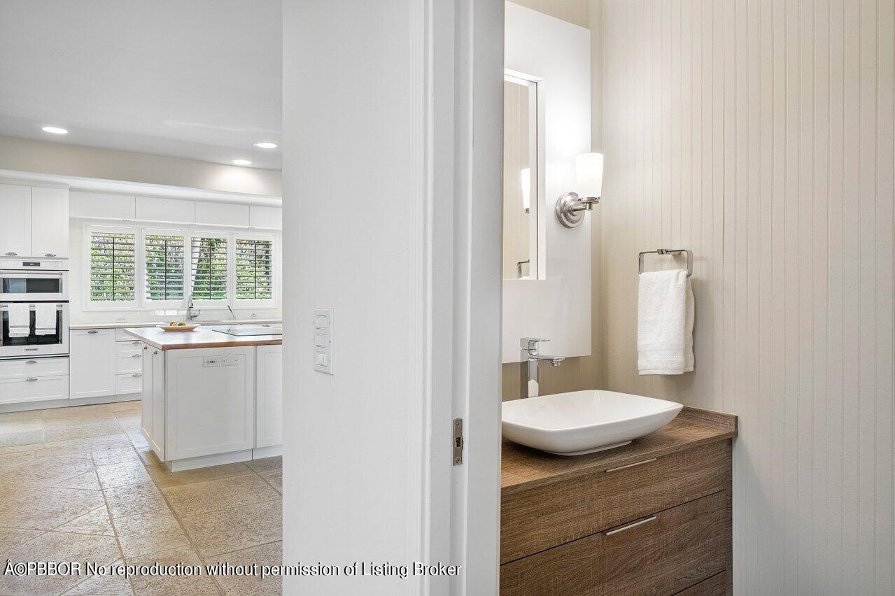 256 Mockingbird Trail Palm Beach, FL 33480 - Photo 10 of 25 a bathroom with a granite countertop sink and a mirror