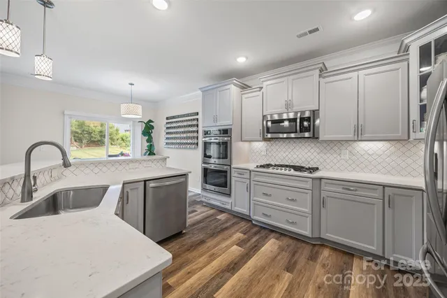 a kitchen with stainless steel appliances granite countertop a stove a sink dishwasher and a refrigerator