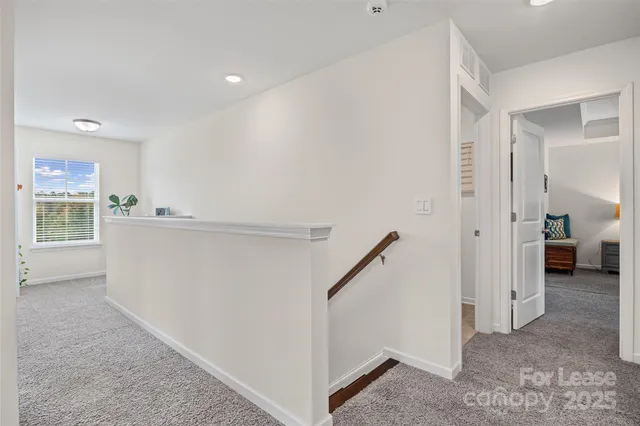a view of a hallway to rooms and stairs