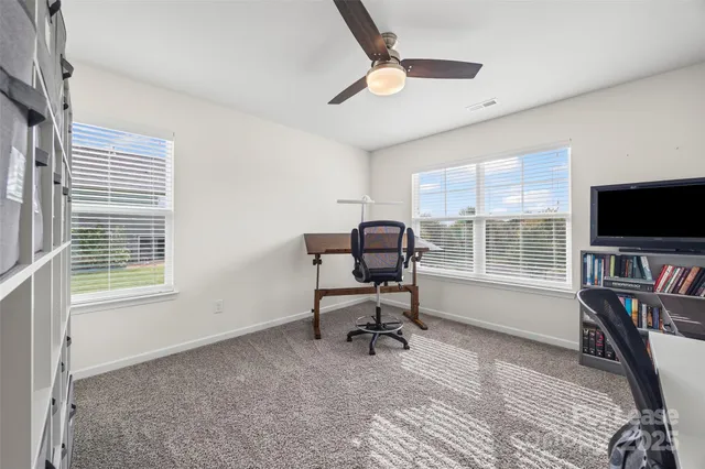 a view of a livingroom with workspace and a window