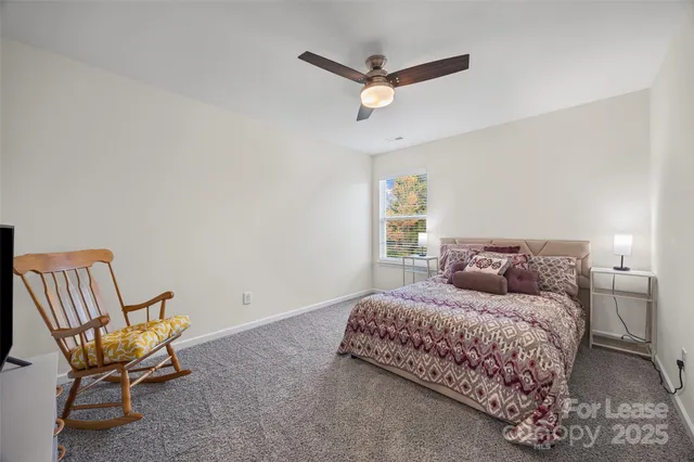 a bedroom with a bed chair and wooden floor
