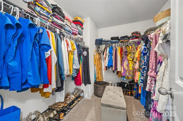 a view of walk in closet with clothes
