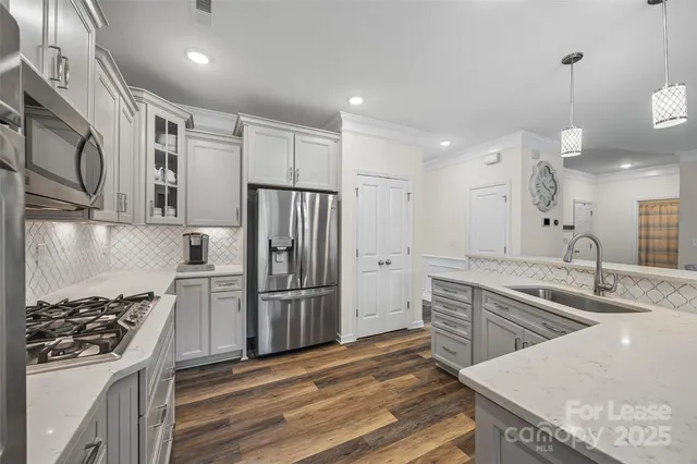 a kitchen with stainless steel appliances granite countertop a sink stove and refrigerator