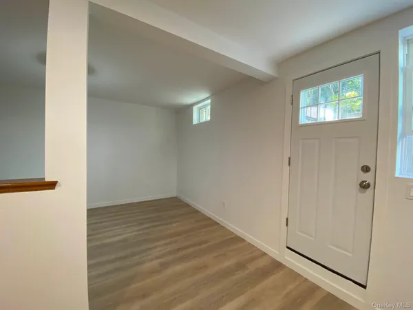 a view of an empty room with closet and a window