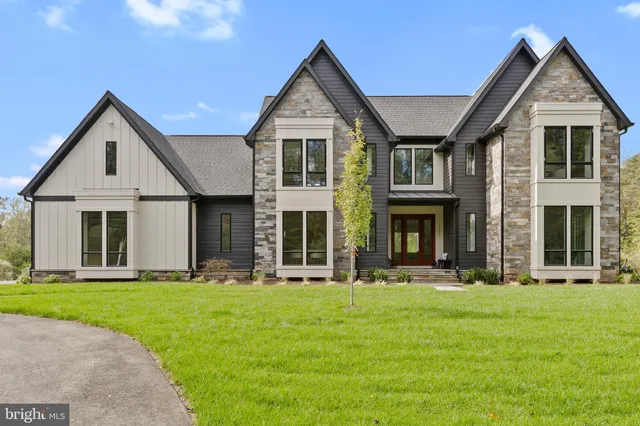 a front view of a house with a yard and trees