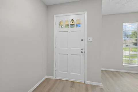 an empty room with windows and door