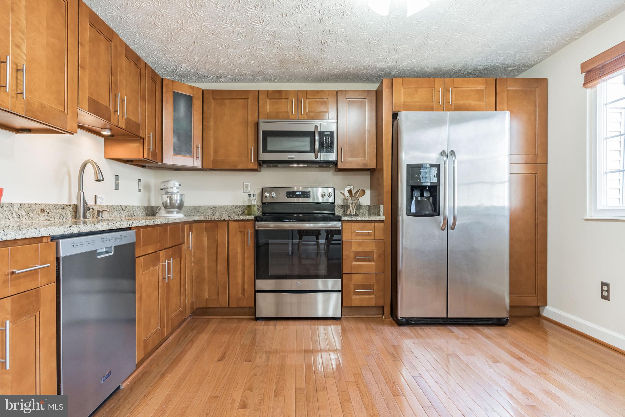 1610 Barnstead Drive Reston, VA 20194 - Photo 10 of 33 a kitchen with stainless steel appliances granite countertop a refrigerator a stove a sink and a microwave