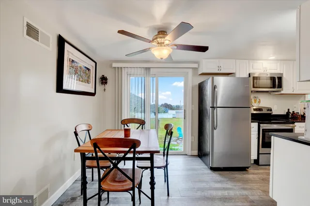 a kitchen with stainless steel appliances a refrigerator a table and chairs