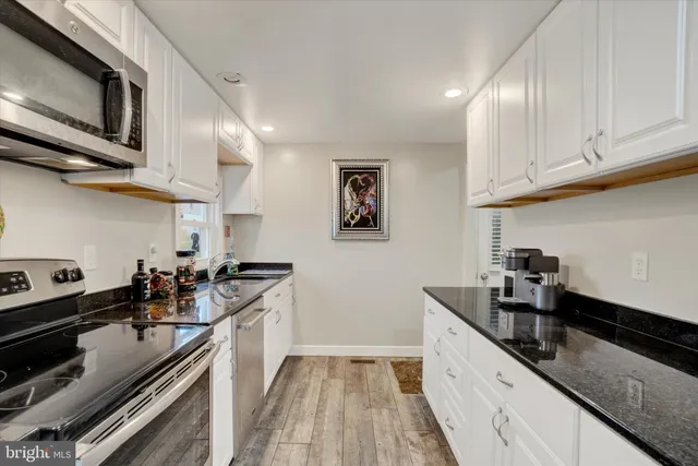 a kitchen with stainless steel appliances granite countertop a sink stove and cabinets