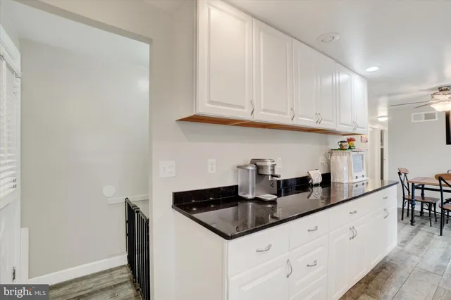 a kitchen with granite countertop a sink stainless steel appliances and cabinets